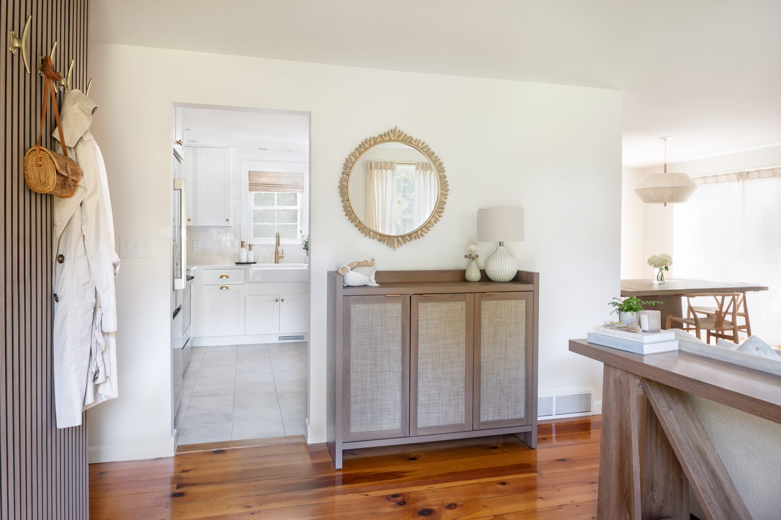 Indian Road entryway with cane cabinet, gold sunburst mirror, and view through to kitchen