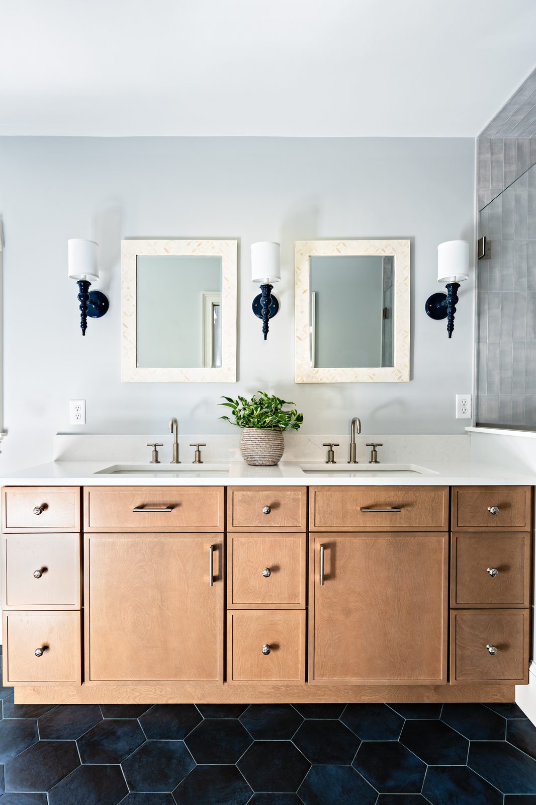 Jerusalem Road bathroom double vanity with white oak cabinetry, paired framed mirrors, and dark hex tile floor