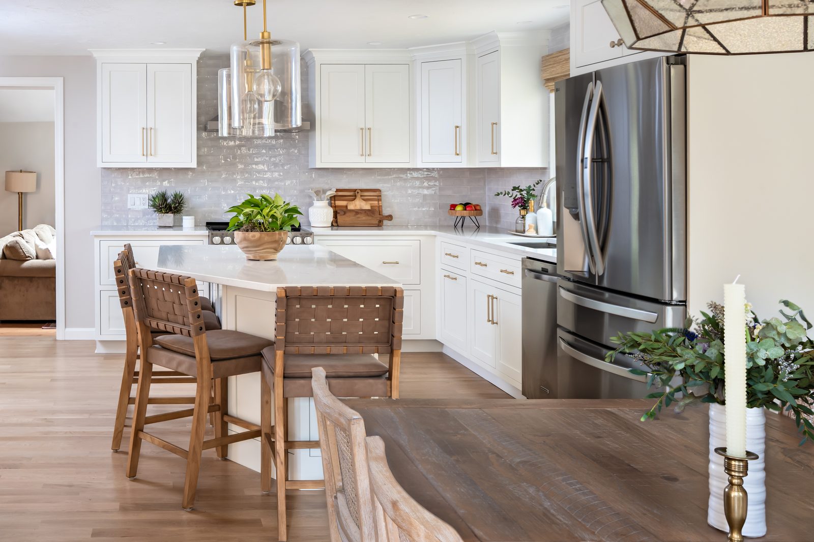 Mill Pond Lane kitchen and dining area with white cabinetry, stainless appliances, and island with woven bar stools