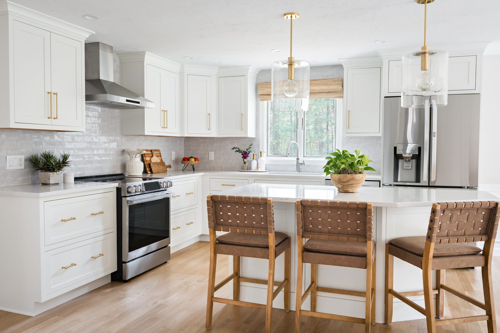 Mill Pond Lane kitchen with white shaker cabinetry, gray zellige backsplash, glass cylinder pendants, and woven bar stools