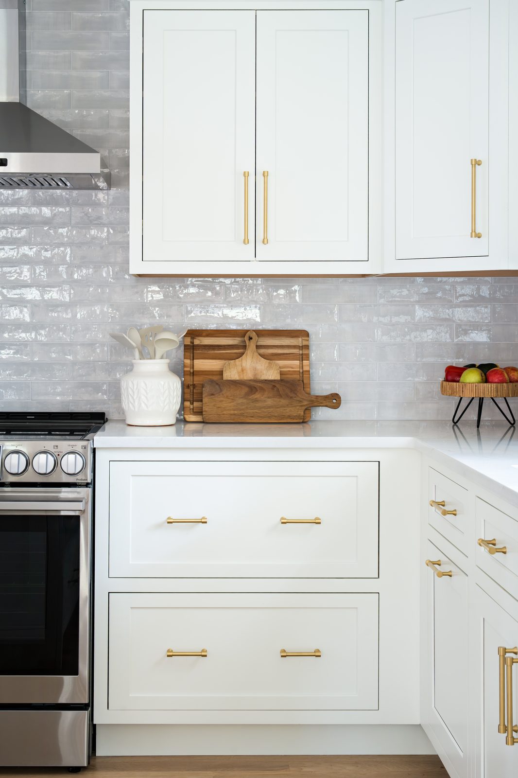Mill Pond Lane kitchen — close-up of range wall with gray zellige tile, stainless range, and gold hardware