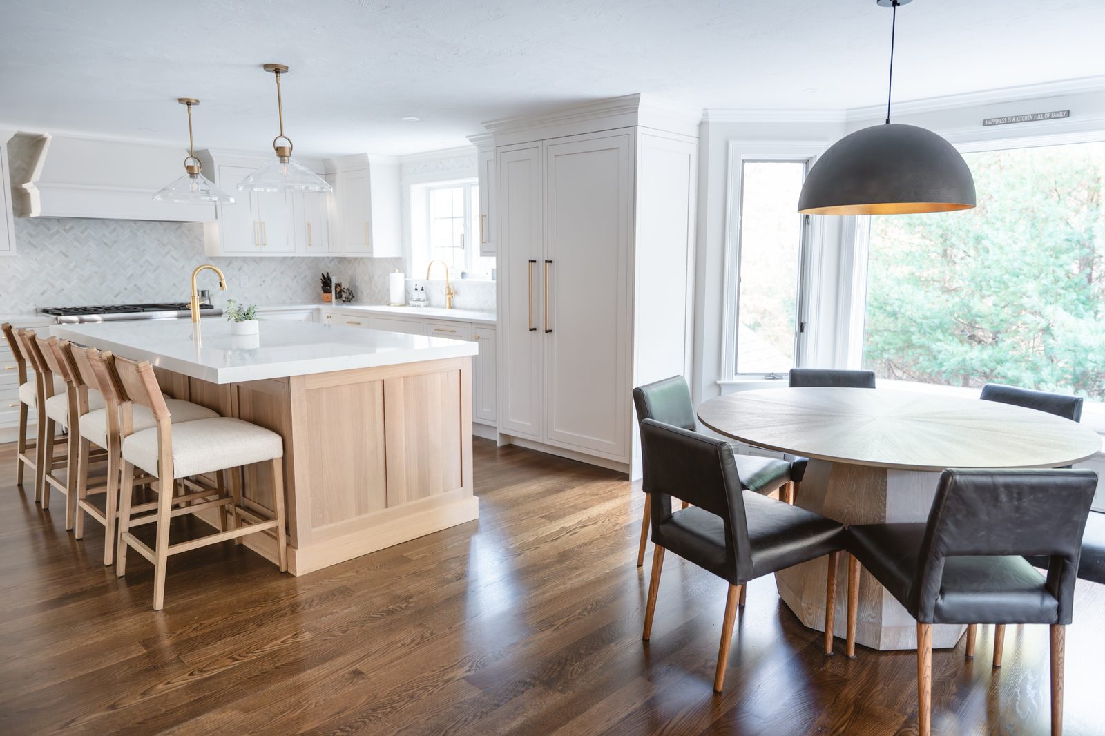 Rosewood Court kitchen and dining area with white cabinetry, white oak island, and round wood dining table
